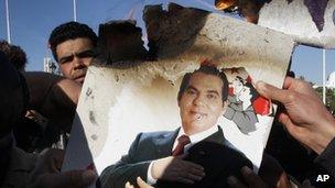 Protestors burn a photo of former President Zine El Abidine Ben Ali during a demonstration in Tunis, Tunisia