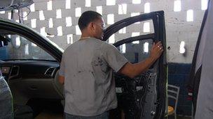 Worker armours a car at an auto workshop in Caracas