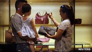 A woman shops for handbags at a Gucci luxury boutique at the IFC Mall in Shanghai June 4, 2012