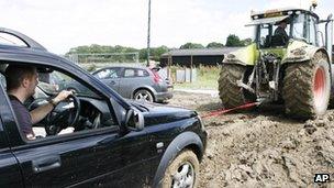 A tractor towing a car