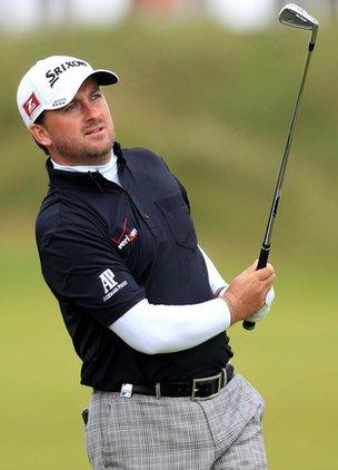 Graeme McDowell watches his ball in flight on the seventh hole