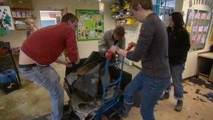 Four people moving and clearing rubbish