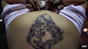 A devotee of the Santa Muerte (Holy Death) religious cult shows a tattoo on his back at at the Iztapalapa shantytown in Mexico City, on February 4,