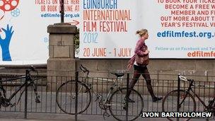 Woman walks past a poster for the EIFF