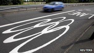 A car passes Olympic traffic lanes markings on a road near Egham south-west of London