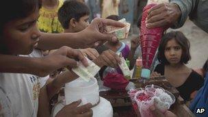 Poor children buy noodles blended in ice in Christian Colony, Islamabad