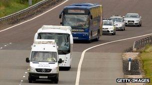 The Megabus coach being driven off the M6 Toll road accompanied by police