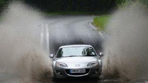 Car driving through a large puddle