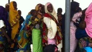 Women holding babies queuing at a clinic