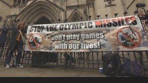 A protester with a banner outside the Royal Courts of Justice