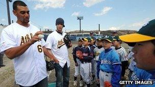 US US Major League Baseball team Oakland Athletics players Tyson Ross (L) and Evan Scribner (2nd L) conduct a baseball skills clinic for Ishinomaki youths during a visit to the Ishinomaki Municipality in March