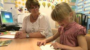 Child reading to teacher