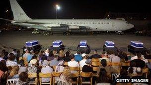 Five coffins draped in Israeli flags set out on the tarmac for a special service with family members