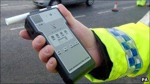 A police officer holds a breath test kit