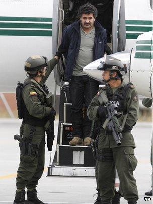 Diego Perez Henao, better known as Diego Rastrojo, is escorted off a plane at Bogota airport