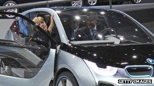 German Chancellor Angela Merkel considers a BMW i3 electric car, alongside chief Norbert Reithofer