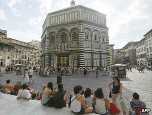 People sit near the Baptistery of San Giovanni in Florence, 26 June 2012