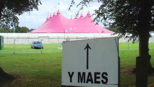 Arwydd 'Y Maes' o flaen y Pafiliwn pinc