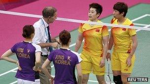 Tournament referee Torsten Berg (2nd L) speaks to players from China (in yellow) and South Korea during their women's doubles group play stage in London on 31 July 2012