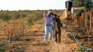 A handout picture released by the Syrian opposition's Shaam News Network on 4 July 2012 shows Syrian rebels walking in a field in Qusayr near Homs, on 3 July