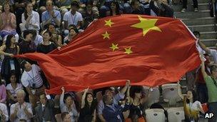 Chinese fans wave their national flag during a winning ceremony at the Aquatics Centre in the London Olympic Park, 29 July 2012