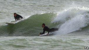 Surfers at the Boscombe reef riding waves