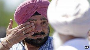 A man wipes away tears outside the Sikh Temple in Oak Creek, Wisconsin, where a shooting took place on 5 August 2012