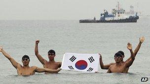 Swimmers holding South Korea's flag in the port city of Uljin