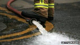 Firefighter pumping flood water out of a property