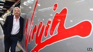 Sir Richard Branson next to a Virgin Pendolino train