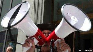 Man shouting into two megaphones