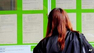 A woman looking into the window of a Job Centre