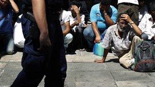 Policeman with immigrants in background