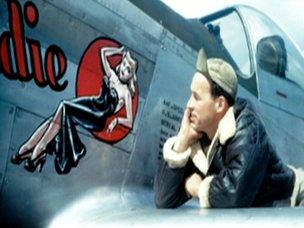 USAAF serviceman Don Allen admires nose art from the wing of a plane