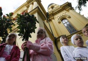 Orthodox Christian children hold flowers at St Mary Magdalene's Orthodox Cathedral in Warsaw, 16 August