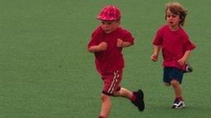 Two children running across school field