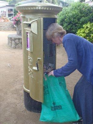 Sark gold postbox being emptied