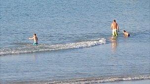 People in the sea on a Guernsey beach