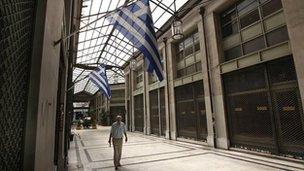 Arcade of shops with "for sale" signs on their windows in Athens (22 August 20120)