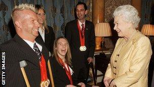 Queen Elizabeth II chats to triple gold medallist equestrian Lee Pearson during a reception for the Great Britain Paralympic team at Buckingham Palace