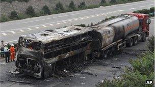 Police officers and rescuers inspect the wreckage of a bus and tanker in Yanan, 26 Aug 2012