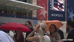 People hide under umbrellas from the rain outside the venue of the Republican national convention in Tampa. Photo: 26 August 2012