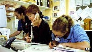 Nurses and health worker at hospital ward desk (model release)