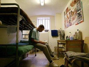 Prison inmate in cell reading a book