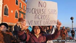 A woman holds a placard reading 'No to cruise ships across Venice lagoon' during a demonstration against the environmental impact of cruise ships (File)