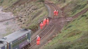 Workmen on the track near the derailed train