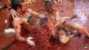 Revelers play with tomato pulp during the annual "tomatina" tomato fight fiesta in the village of Bunol, near Valencia