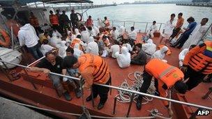 Asylum-seeker survivors are seen onboard an Indonesian rescue boat at Merak seaport on 31 August, 2012