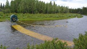 A green tower sits in a river