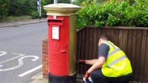 Royal Mail painting a gold postbox in Belton